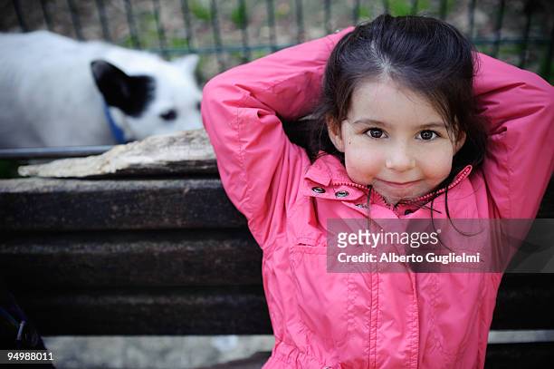 portraits of a girl in pink sitting on a bench - alberto guglielmi stock pictures, royalty-free photos & images