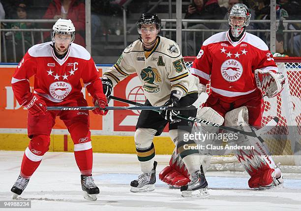 Leigh Salters of the London Knights waits to deflect a shot between Jacob Muzzin and Bryce O'Hagen of the Sault Ste. Marie Greyhounds in a game on...