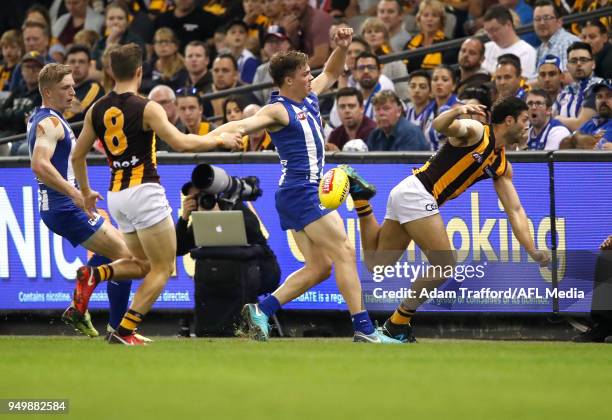 David Mirra of the Hawks is pushed into the fence by Cameron Zurhaar of the Kangaroos during the 2018 AFL round five match between the North...