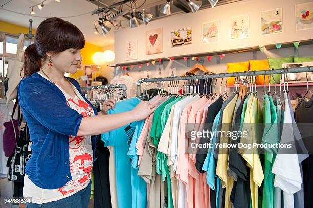 woman looking at clothes in store - gift shop ストックフォトと画像