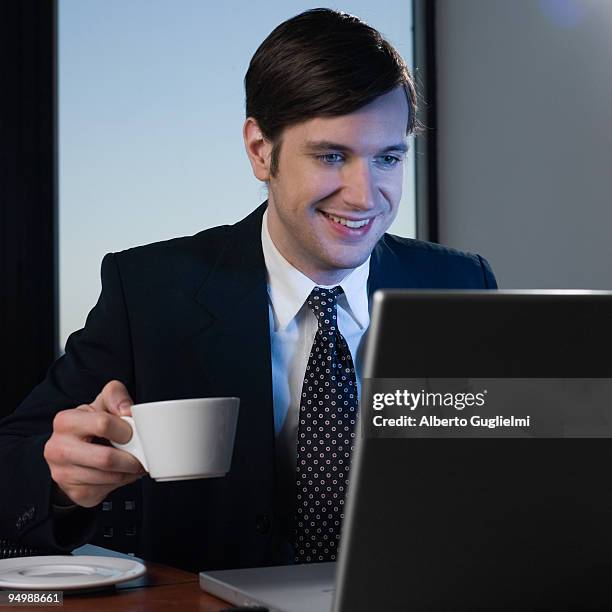 man drinking in front of the computer - alberto guglielmi imagens e fotografias de stock