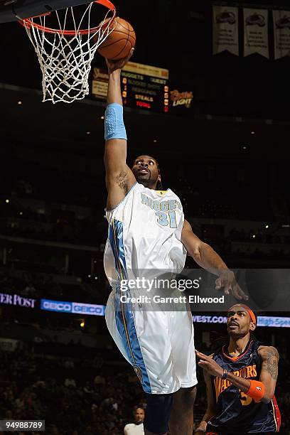 Nene of the Denver Nuggets goes for the dunk as Mikki Moore of the Golden State Warriors looks on during the game on December 1, 2009 at the Pepsi...