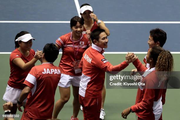 Team captain Toshihisa Tsuchihashi of Japan celebrates the 3-2 victory with members of the Japan Fed Cup team after the doubles match between Miyu...