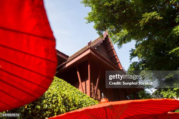 thai house and red umbrella - sunphol stock-fotos und bilder