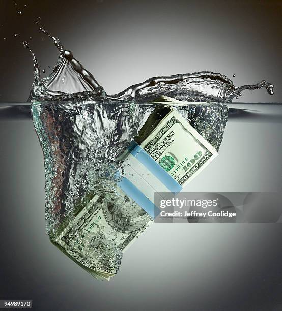 us currency splashing in water - u.s. economy stock pictures, royalty-free photos & images