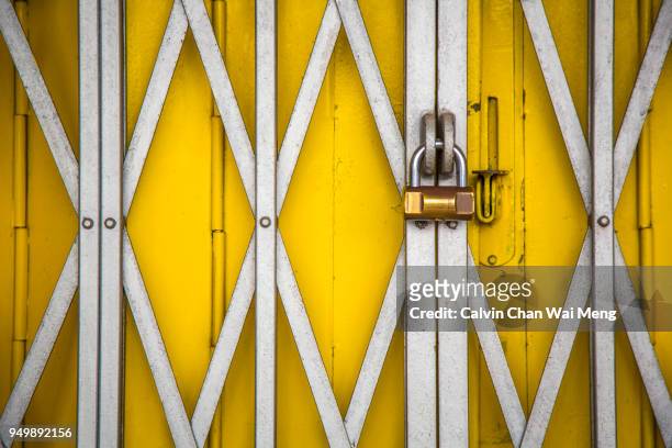 locked metal gate - yellow door stock pictures, royalty-free photos & images