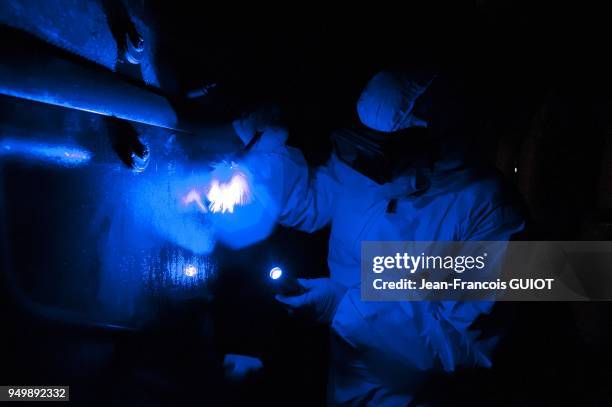 Recherche d'empreintes digitale a l'aide d'une crimelight en eclairage bleu, lors d'une simulation d'intervention par le laboratoire de police...