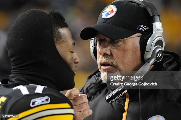 Offensive coordinator Bruce Arians of the Pittsburgh Steelers talks with wide receiver Mike Wallace on the sideline during a game against the Green...