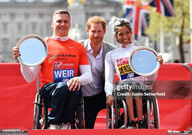 Prince Harry poses with David Weir of Great Britain and Madison de Rozario of Australia as they receive their trophies, following their first place...