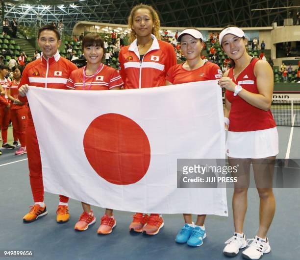 Japan's head coach Toshihisa Tsuchihashi poses with players Kurumi Nara, Naomi Osaka, Makoto Ninomiya and Miyu Kato as they hold their national flag...
