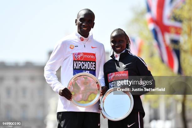 Eliud Kipchoge and Vivian Cheruiyot of Kenya pose as they receive their trophies, following their first place results during the Virgin Money London...