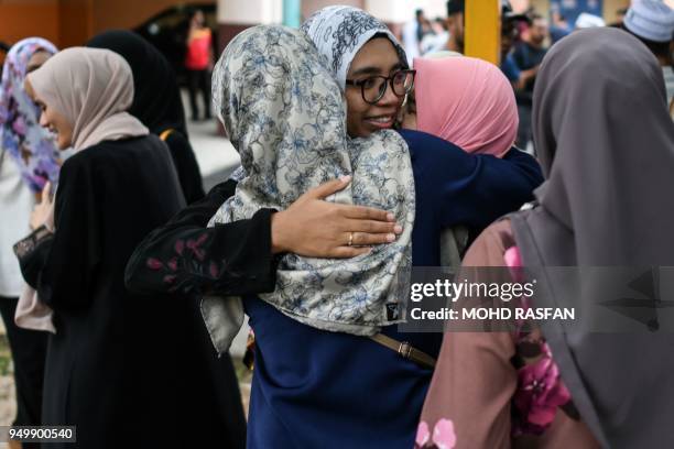 Students of Palestinian professor Fadi Mohammad al-Batsh, who was killed in a drive-by shooting on April 21, hug each other outside the compound of...