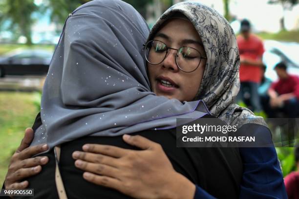 Students of Palestinian professor Fadi Mohammad al-Batsh, who was killed in a drive-by shooting on April 21, hug each other outside the compound of...