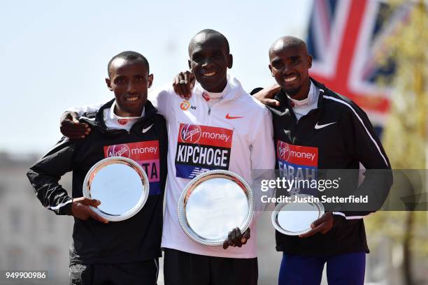 Second placed Tola Shura Kitata of Ethiopia, winner Eliud Kipchoge of Kenya and third placed Mo Farah of Great Britain pose with their trophies...