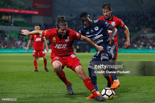 Leroy George of the Victory contests th ball with Michael Marrone of Adelaide United and Vince Lia of Adelaide United during the A-League Elimination...