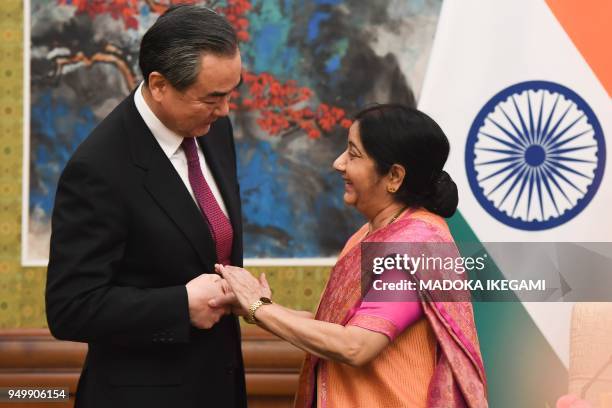 India's Foreign Minister Sushma Swaraj shakes hands with China's Foreign Minister Wang Yi as a press conference begins at the Diaoyutai State Guest...