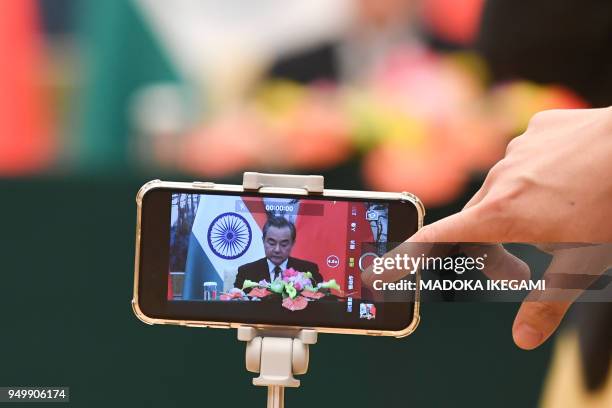 Reporter records a video of China's Foreign Minister Wang Yi speaking during his press conference with India's Foreign Minister Sushma Swaraj at the...