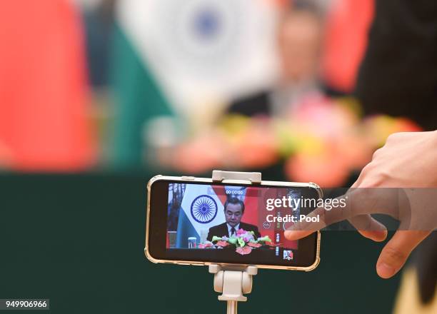 Reporter records a video of Chinese Foreign Minister Wang Yi speaking during his press conference with Indian Foreign Minister Sushma Swaraj at the...