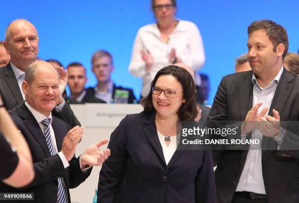 Parliamentary group leader of the Social Democratic Party Andrea Nahles is applauded by German Finance Minister and Vice-Chancellor Olaf Scholz and...