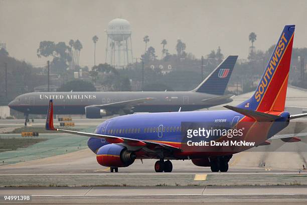 United Airlines and Southwest Airlines jets taxi at Los Angeles International Airport after a snow storm on the East Coast caused the cancellation of...