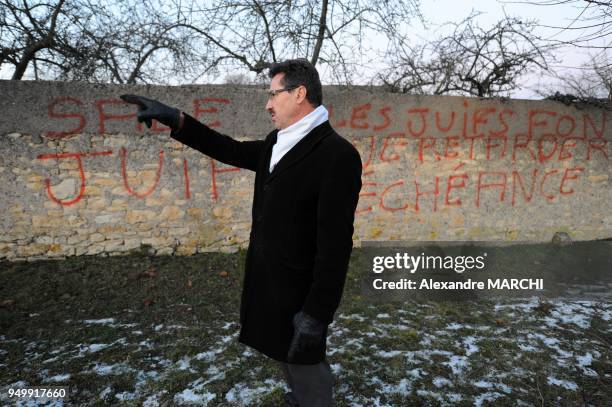 The mayor Henri Poirson in front of the anti-semitic tags.