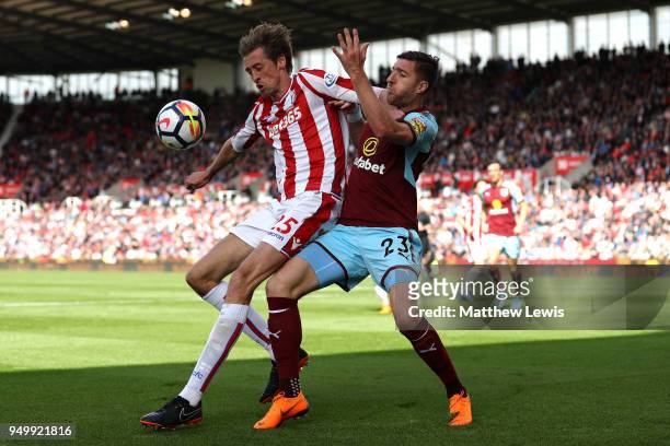 Peter Crouch of Stoke City and Stephen Ward of Burnley battle for the ball during the Premier League match between Stoke City and Burnley at Bet365...