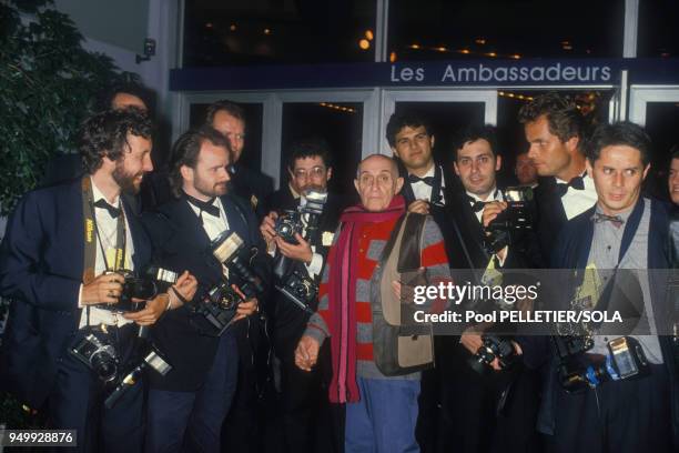 Le photographe de plateau Roger Corbeau entouré de photographes au Festival de Cannes le 9 mai 1986, France.