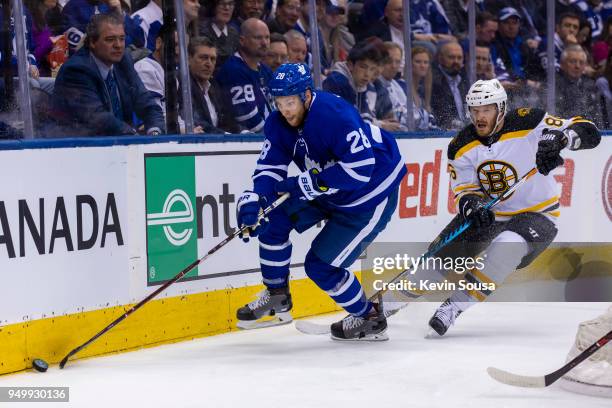 Nikita Zaitsev of the Toronto Maple Leafs skates with the puck against David Pastrnak of the Boston Bruins in Game Four of the Eastern Conference...