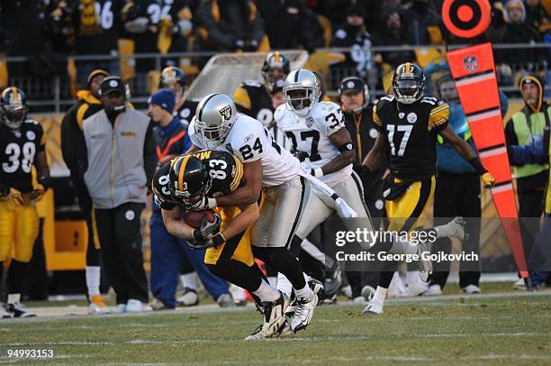 Safety Michael Huff of the Oakland Raiders tackles tight end Heath Miller of the Pittsburgh Steelers during a game at Heinz Field on December 6, 2009...