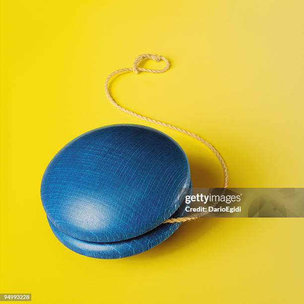 blue yo-yo on yellow background - jojo stockfoto's en -beelden