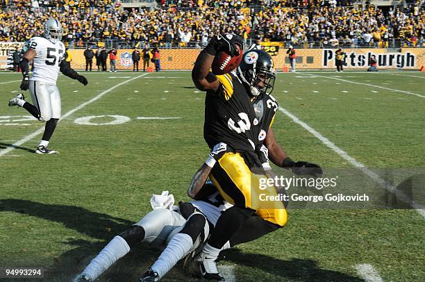 Cornerback Chris Johnson of the Oakland Raiders tackles running back Rashard Mendenhall of the Pittsburgh Steelers at Heinz Field on December 6, 2009...