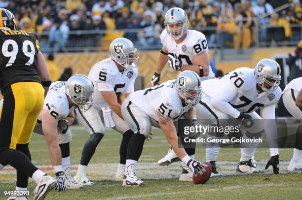 Quarterback Bruce Gradkowski of the Oakland Raiders stands behind center Chris Morris as offensive linemen Cooper Carlisle and Langston Walker and...