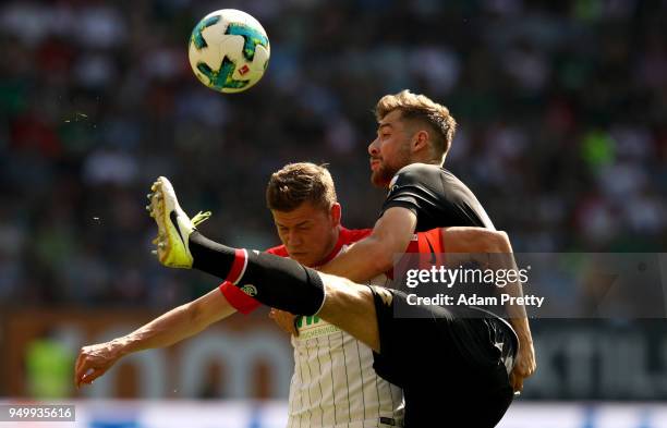 Alfred Finnbogason of Augsburg and Alexander Hacker of Mainz battle for the ball during the Bundesliga match between FC Augsburg and 1. FSV Mainz 05...