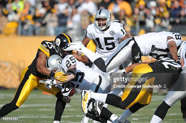 Safety Ryan Clark of the Pittsburgh Steelers tackles running back Justin Fargas of the Oakland Raiders as wide receiver Louis Murphy blocks...