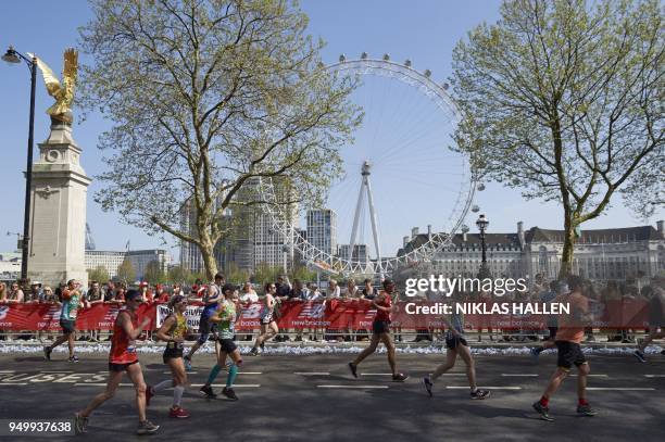 Participants run with the London Eye in the background at the 2018 London Marathon in central London on April 22, 2018. -