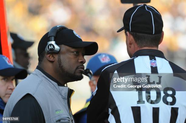 Head coach Mike Tomlin of the Pittsburgh Steelers talks with line judge Gary Arthur during a game against the Oakland Raiders at Heinz Field on...