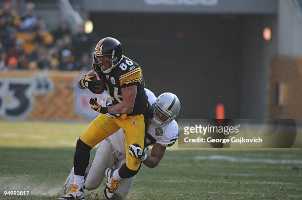 Wide receiver Hines Ward of the Pittsburgh Steelers is tackled by safety Tyvon Branch of the Oakland Raiders at Heinz Field on December 6, 2009 in...