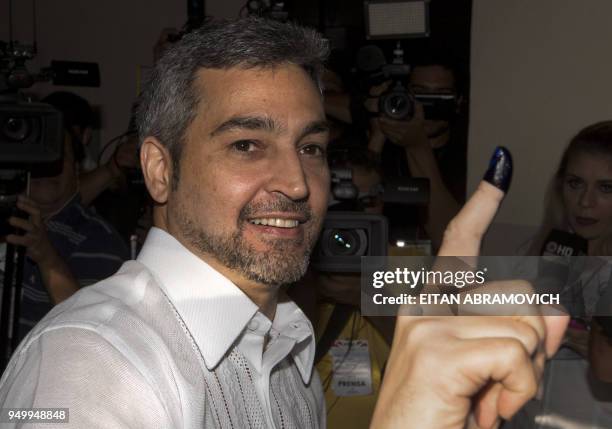 Paraguay's presidential candidate of the Colorado Party, Mario Abdo Benitez shows his inked finger next to and his wife Silvana Lopez Moreira after...