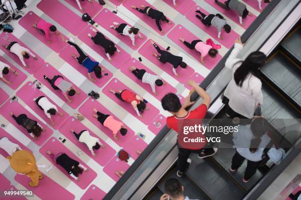 One hundred citizens do yoga to welcome the Earth Day at a shopping mall on April 21, 2018 in Taiyuan, Shanxi Province of China. One hundred citizens...