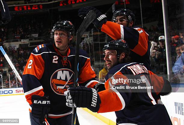 Mark Streit and Frans Nielsen of the New York Islanders join Nate Thompson in celebrating Thompson's first goal of the season in the second period...