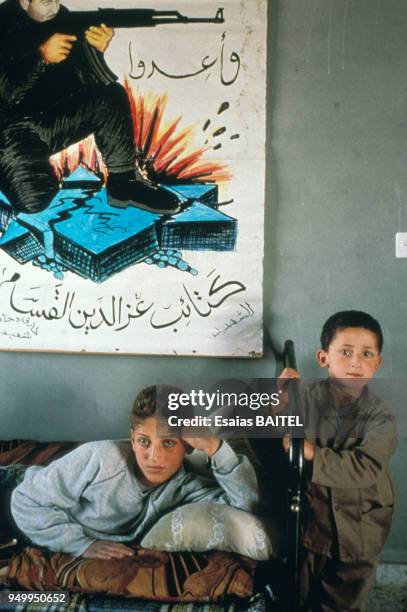 Deux jeunes garçons palestiniens posent sous le portrait de leur frère aîné tué par des soldats israéliens en mai 1993 en Israël.