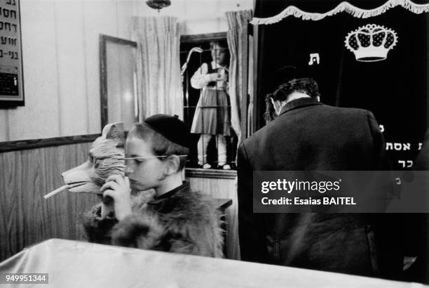 Un enfant met un masque sur son visage pendant la fête de Pourim - Purim - dans une communauté de Juifs orthodoxes en décembre 1996 à Jérusalem,...