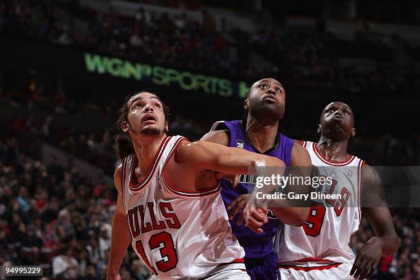 Joakim Noah and Luol Deng of the Chicago Bulls box out Kenny Thomas of the Sacramento Kings during the NBA game on December 21, 2009 at the United...