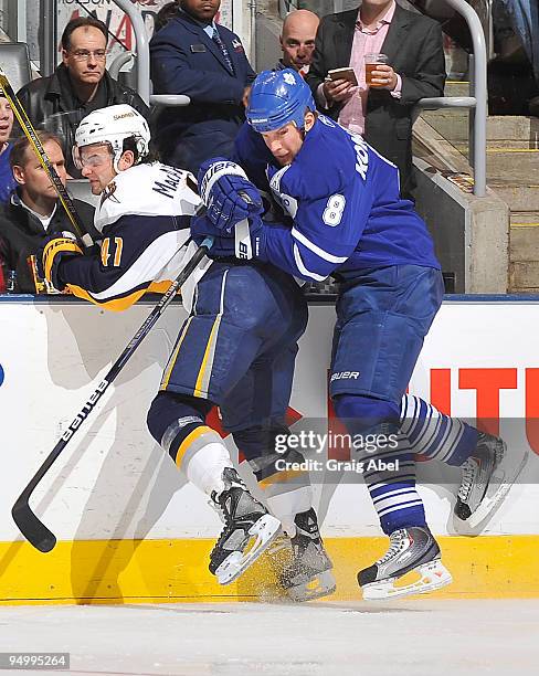 Mike Komisarek of the Toronto Maple Leafs checks Clarke MacArthur of the Buffalo Sabres during game action December 21, 2009 at the Air Canada Centre...