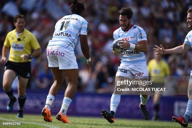 Racing 92's French winger Teddy Thomas passes the ball to Racing 92's French scrum-half Maxime Machenaud to score a try during the European Champions...