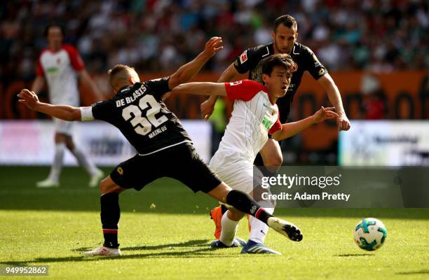 Ja Cheol Koo of Augsburg and Pablo de Blasis of Mainz battle for the ball during the Bundesliga match between FC Augsburg and 1. FSV Mainz 05 at...