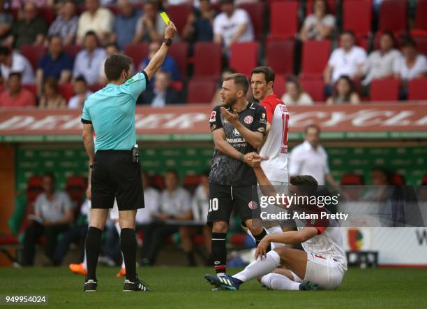 Referee Frank Willenborg shows the yellow card to Alexandru Maxim of Mainz during the Bundesliga match between FC Augsburg and 1. FSV Mainz 05 at...