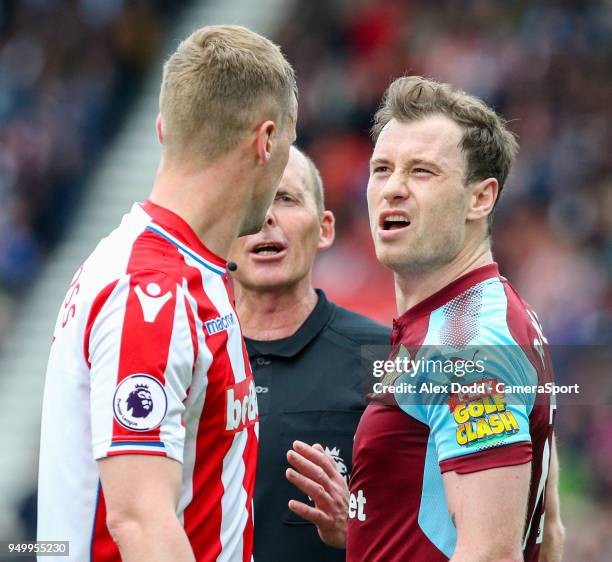 Referee Mike Dean intervenes as Burnley's Ashley Barnes and Stoke City's Ryan Shawcross square up during the Premier League match between Stoke City...