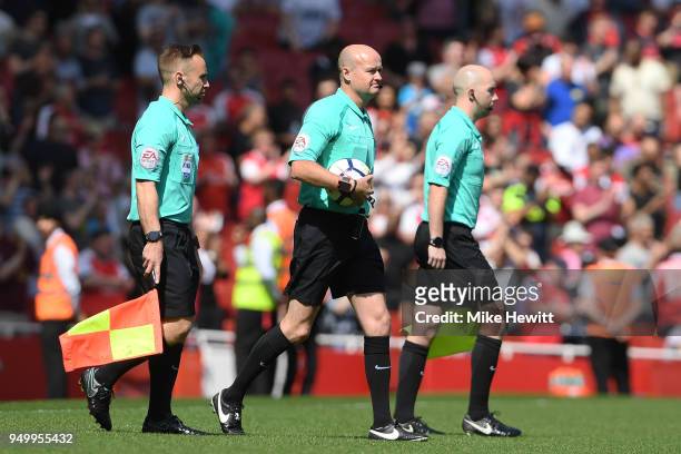 Referee Lee Mason walks out with assistants Harry Lennard and Matthew Wilkes during the Premier League match between Arsenal and West Ham United at...