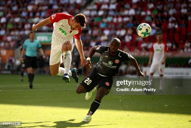 Rani Khedira of Augsburg and Anthony Ujah of Mainz head for the ball during the Bundesliga match between FC Augsburg and 1. FSV Mainz 05 at WWK-Arena...